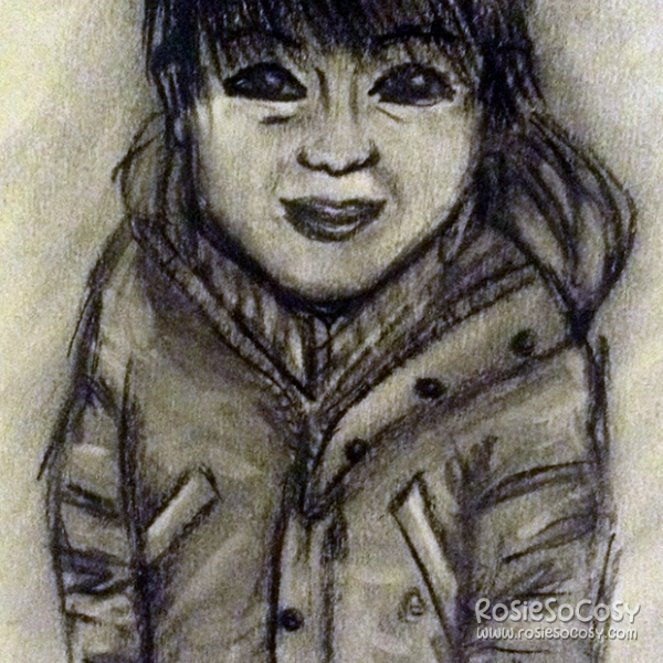 A charcoal drawing of a little boy. He has a light to medium skin colour, and darkbrown hair which reaches the top of his eyes. He is wearing a thick winter coat, with buttons and pockets on both sides. The boy has a timid smile on his face.