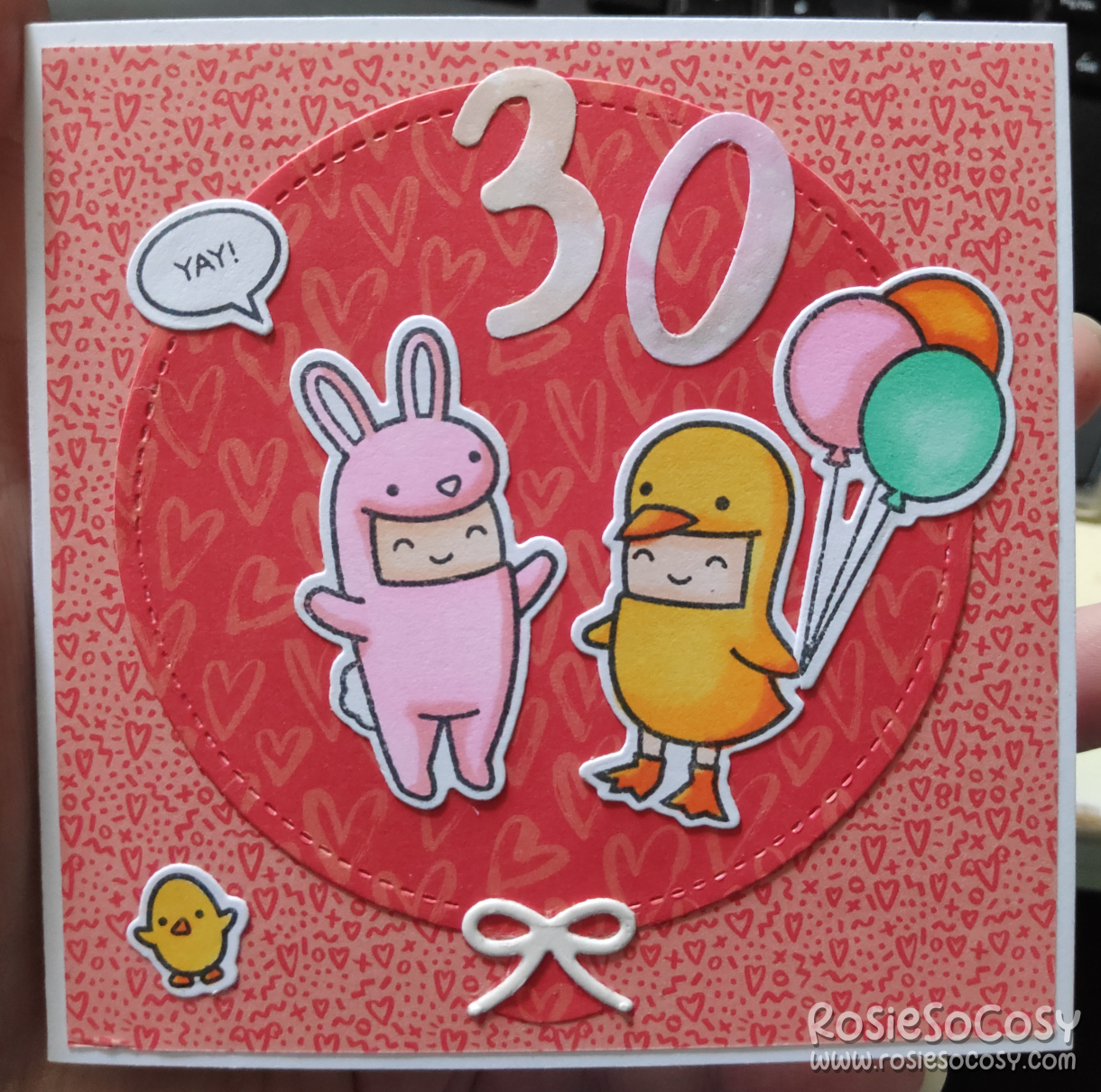 A red birthday card with two characters, dressed up as a pink bunny and a yellow chick. Above it there's 30 in white. The background is a red balloon. There's a small yellow chick in the bottom left corner. The character with yellow chick is holding 3 balloons in pink, orange and turquoise.